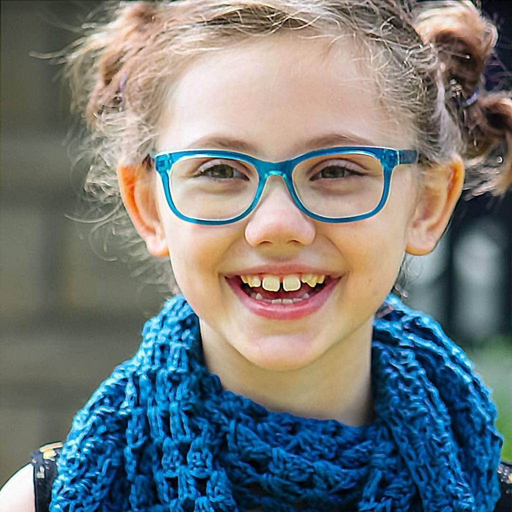 Little girl wearing crocheted blue shawl