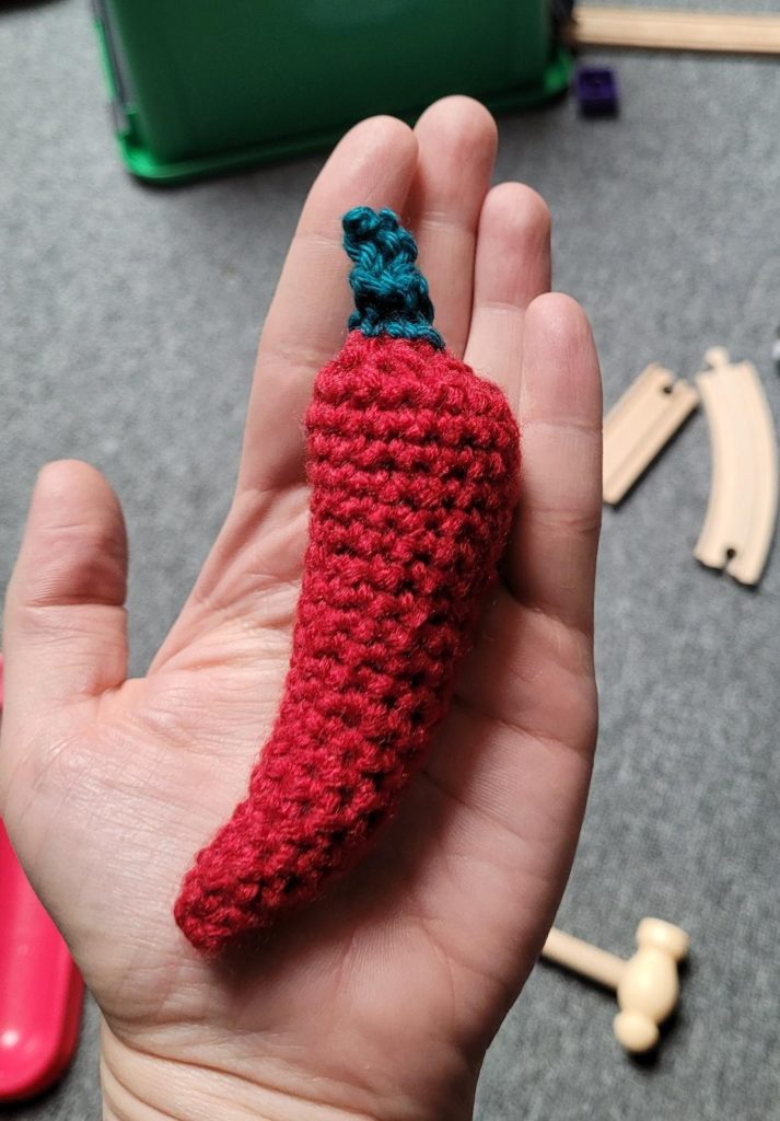 Crocheted chili pepper in hand