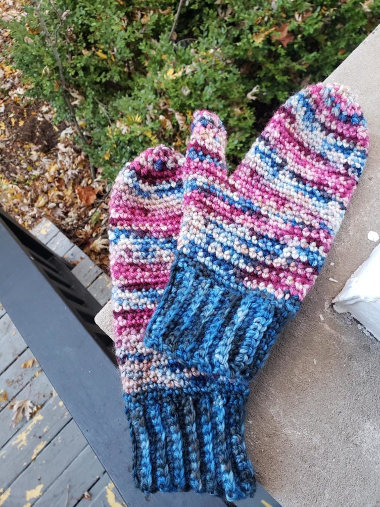 Crocheted mittens laying on a porch