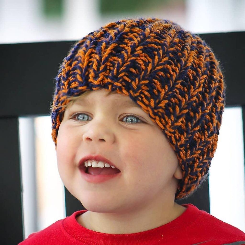 Little boy wearing orange and blue knitted hat