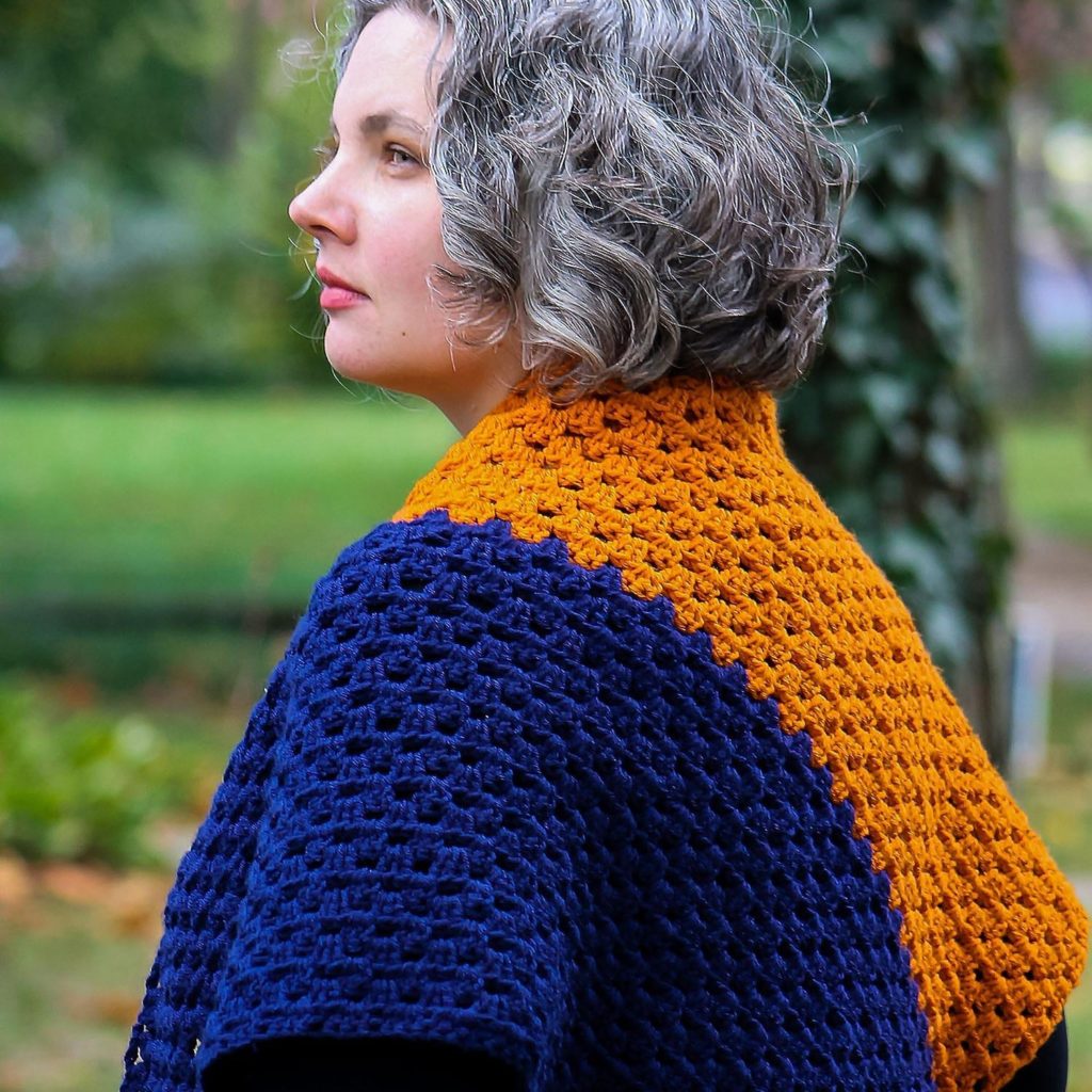 Kim wearing crocheted orange and blue shawl