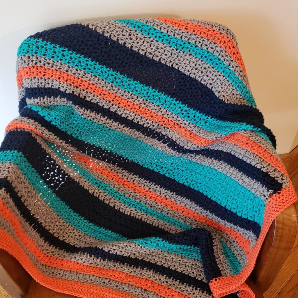 Crocheted orange and blue striped baby blanket